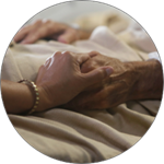 a patient and a caregiver holding hands